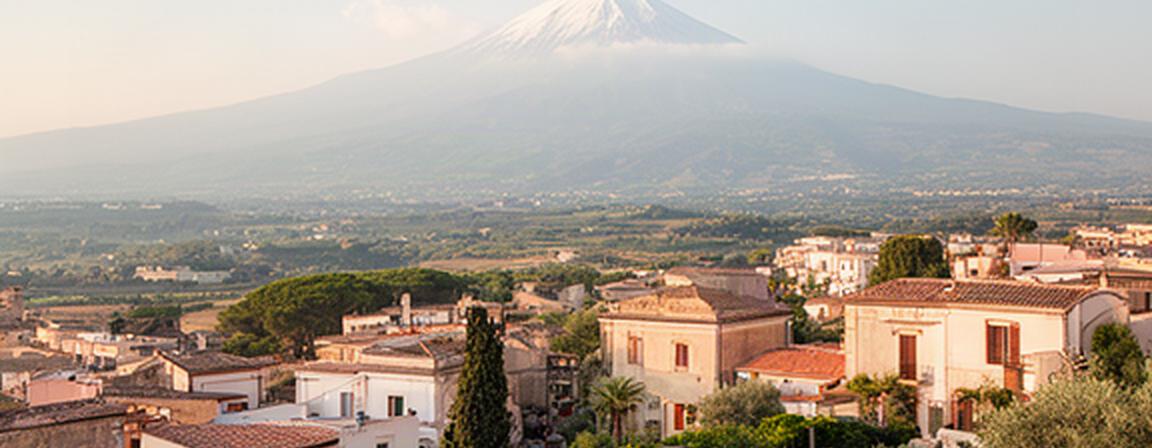 Vista di Valverde in Sicilia con profilo dell'Etna e architetture residenziali nella luce del pomeriggio