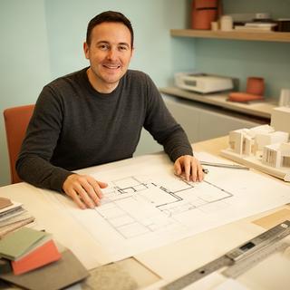 Designer Badawi Romezzano mentre consulta una pianta d'interni nello studio di Valverde